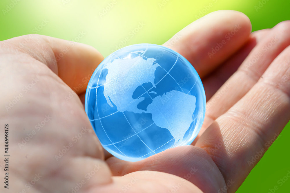 Blue Glass globe of the planet Earth in human hand Blue Glass globe of the planet Earth in human hand