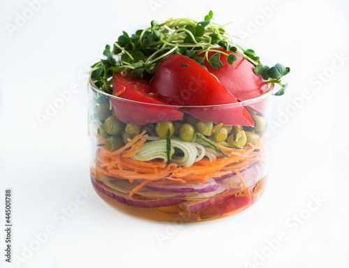 A snack of raw vegetables in a glass. Bright vegetables on a white background