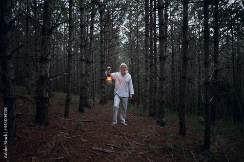 A vitiligo man with a kerosene lamp in the dark forest