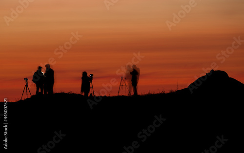 Silhouettes of people in a photography workshop during sunset. Long exposure shot.