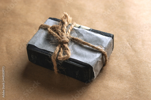 A block of natural carbon soap on craft paper