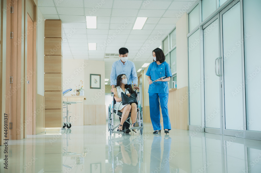 Obraz premium doctor medical team assistant patient who is sitting on wheelchair, explaining prescription to young asian patient, healthcare concept. wearing face mask during covid-19 pandemic.