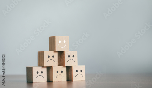 The best business services rate the customer experience. sorted by service level Satisfaction Survey Concept With a business wooden block, choose a smiley face on the top wooden block.