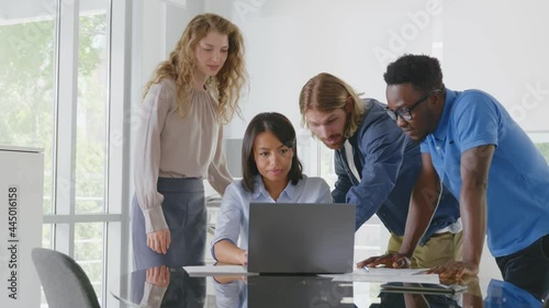 Group of young confident business people analyzing data using computer