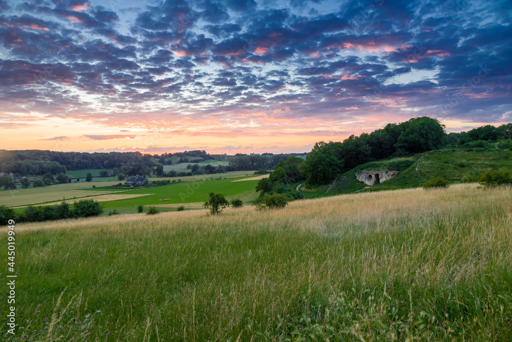Long exposure image of an amazing sunset over the valley in Maastricht with a dramatic sky, showing amazing colors and impressive landscape views with on a view of Devils cave a former quarry