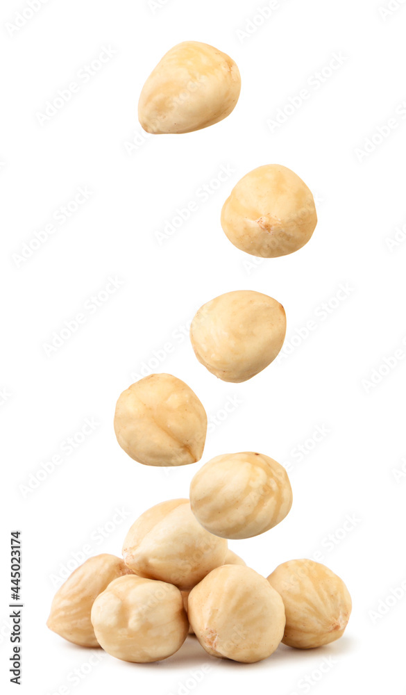Peeled hazelnuts fall on a heap on a white background. Isolated