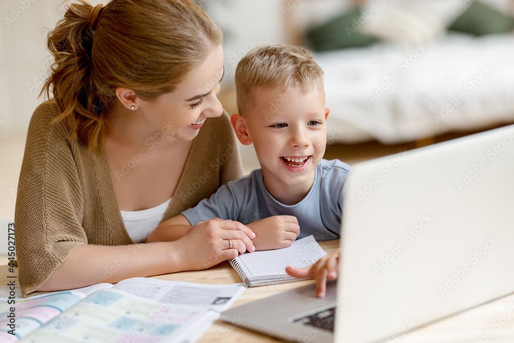Happy mother supporting son during online studies Happy mother supporting son during online studies