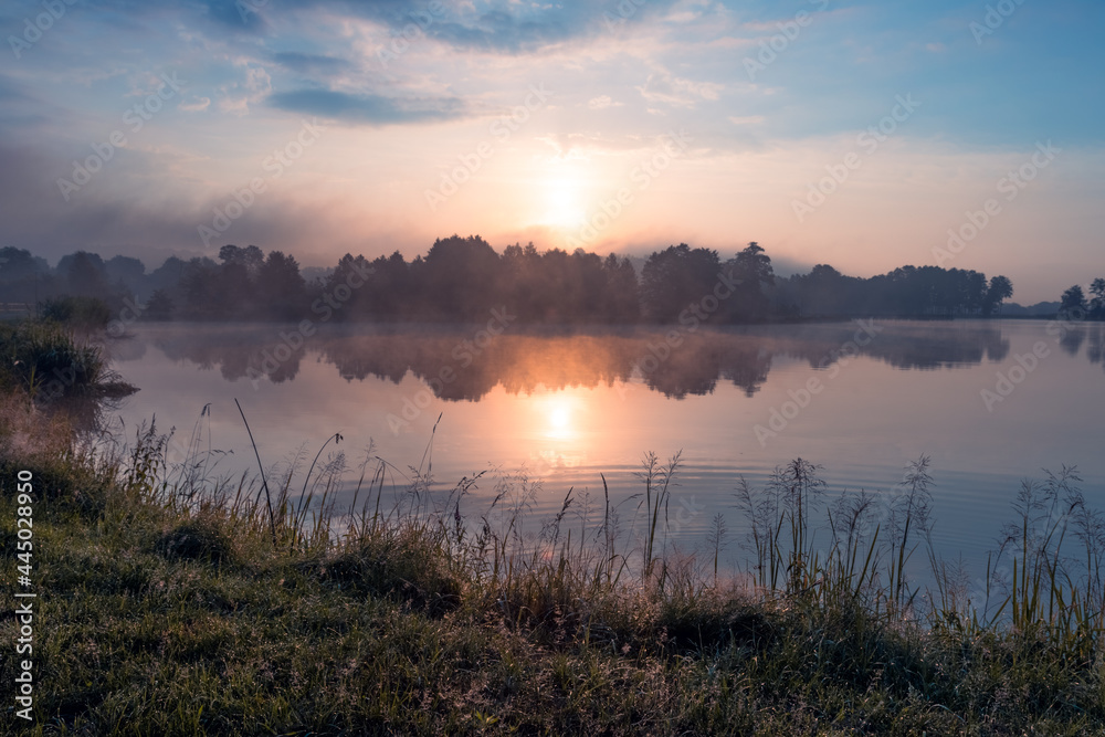 Beautiful sunrise at lake surrounded by forest in Krasnobród, Roztocze, Poland.
