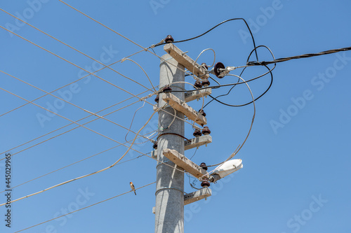 A high voltage utility pole and tangled electrical cables
