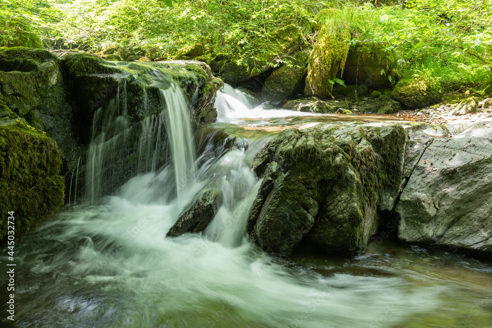 Fototapeta premium Long exposure of a waterfall on the Hoar Oak Water river at Watersmeet in Exmoor National Park
