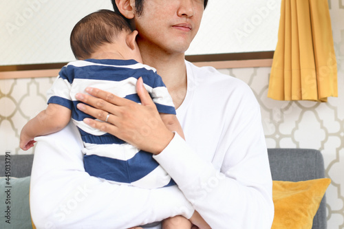 赤ちゃんを抱く若い父親