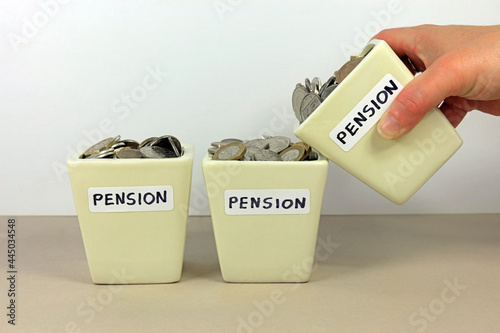 A Hand Tipping A Pension Pot In To Another. Consolidating Multiple Pensions Concept photo