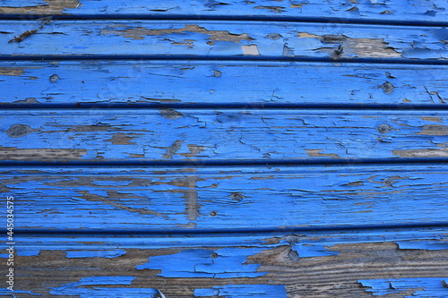 Torn blue wooden wall. Flaked wood plank, the bluish color loosen. Old worn part of a house. Plenty of copy space. Close-up and isolated. Stockholm, Sweden, Europe.