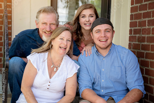 Φωτογραφία Casual outdoor summer family portrait of parents and adult son and daughter sitt
