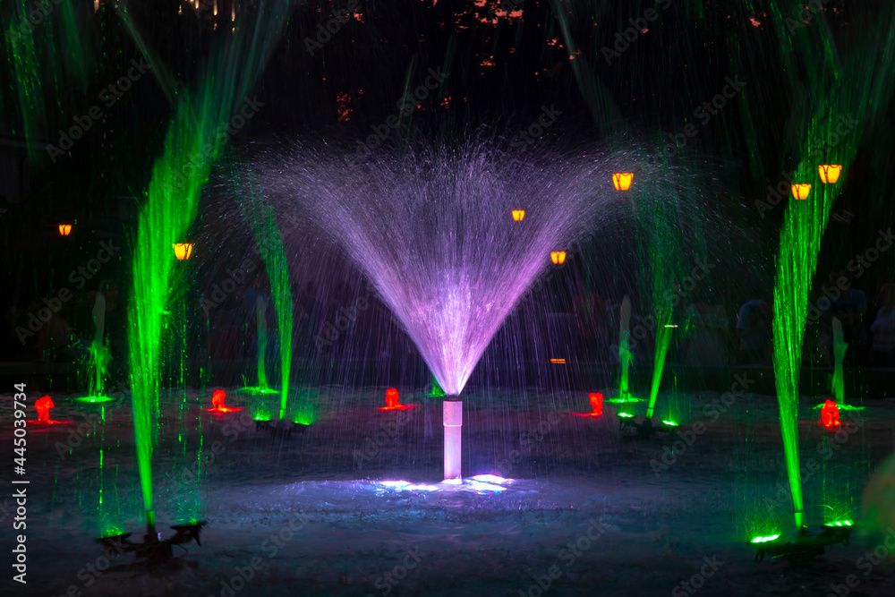 City fountain in the evening in the colored light of LEDs