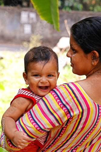 mother holding an indian cute baby boy with smile