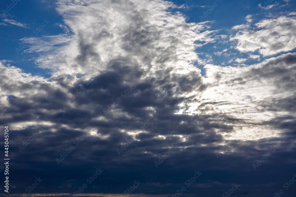 Obraz premium Dramatic cloud formation with dark blue sky peaking through clearing