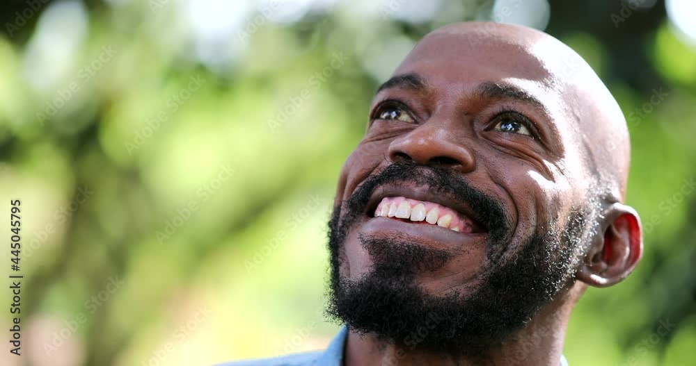 Smiling happy black African man looking up at sky