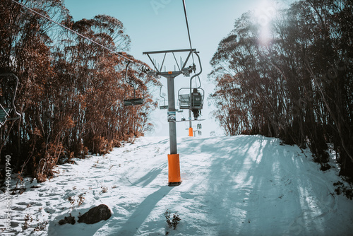 People in winter enjoying the snowy mountains where are practised plenty of activities such as skiing and snowboarding with a clear sky and some clouds on the horizon. photo