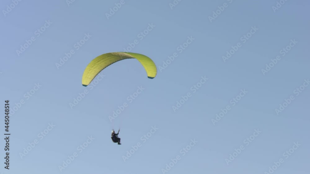 Paraglider flies against the background of a blue sky. Paraglider flies against the background of a blue sky.