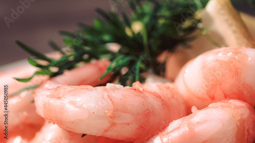 Close up of peeled fresh shrimps on white bread, making a delicious Swedish shrimp sandwich (räkmacka).
Seafood and food preparation concept.