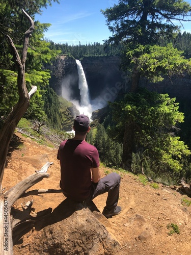 Male hiker is looking at Helmcken Falls - a famous waterfall in Wells Gray Provincial Park in British Columbia, Canada photo