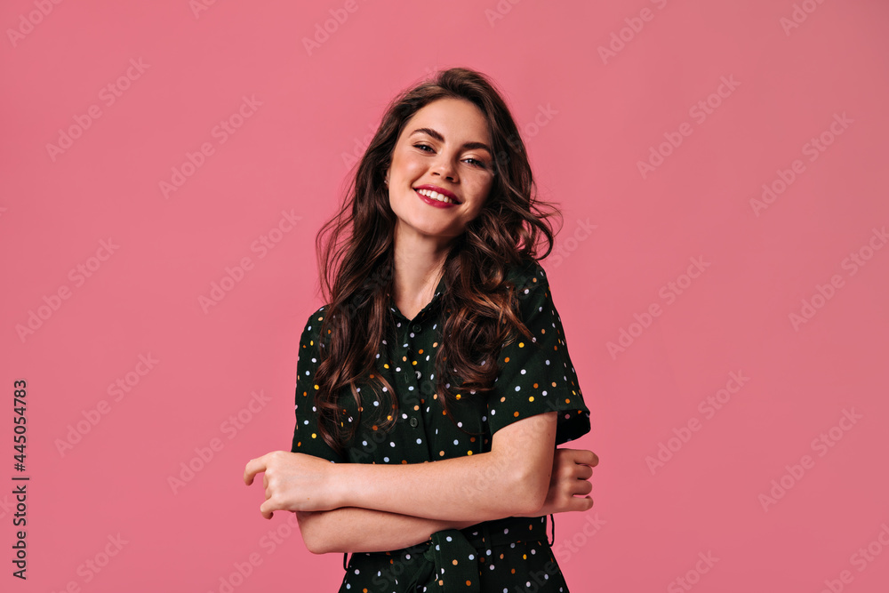 Charming woman in black dress smiling on pink background. Beautiful girl with red lipstick and in polka dot dress laughing cute Charming woman in black dress smiling on pink background. Beautiful girl with red lipstick and in polka dot dress laughing cute