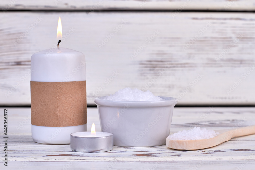 Candles and white salt for spa treatment on wooden desk. Candles and white salt for spa treatment on wooden desk.