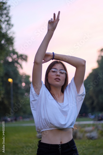 Sporty and young teen female model posing in the park on a summer evening