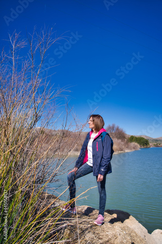 mujer posando en lago con mochila © saltacekias