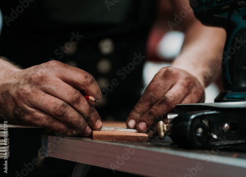 Close up of hands working on a piece of wood photo