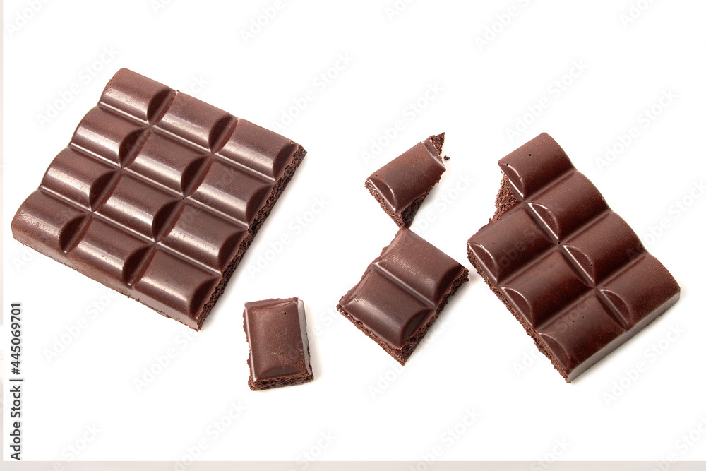 Broken bar of dark porous chocolate, pieces of chocolate on white isolated background Broken bar of dark porous chocolate, pieces of chocolate on white isolated background