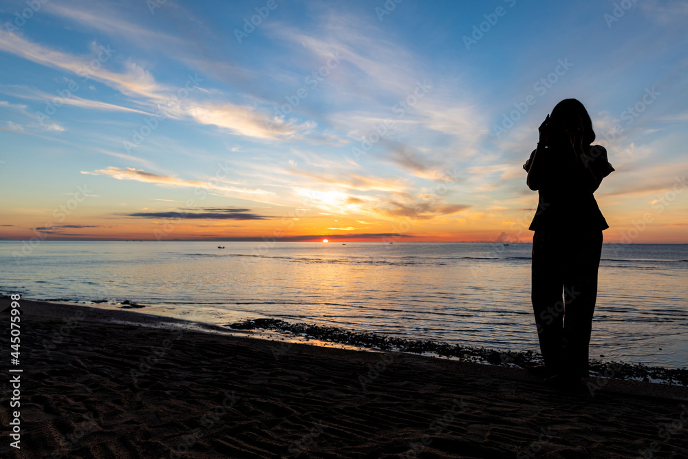 silhouette, Romantic woman  on the beach for looking sunset over the sea