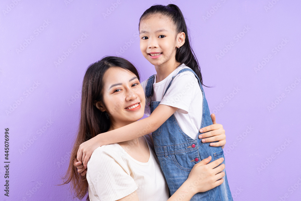 Portrait of Asian mother and daughter on purple background Portrait of Asian mother and daughter on purple background