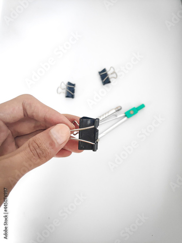 left handed holding black papr clip 