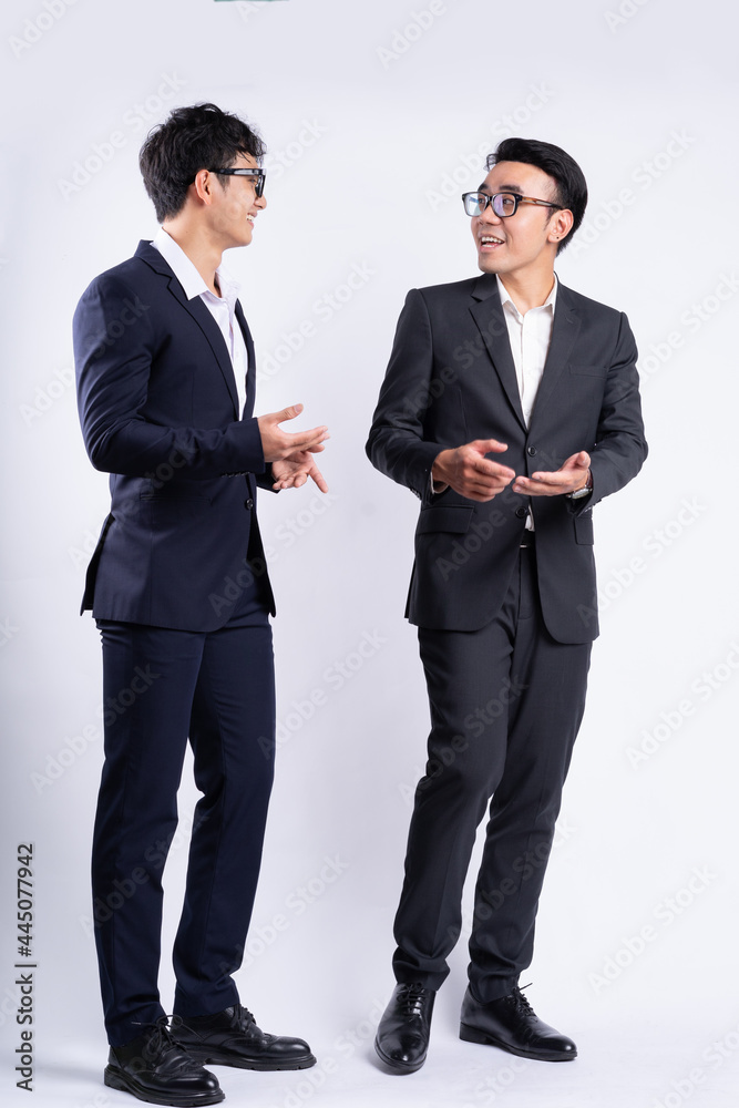 Two Asian businessmen walking on white background Two Asian businessmen walking on white background