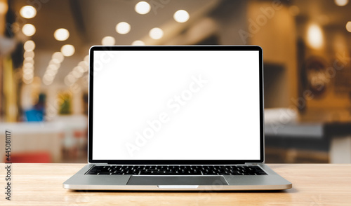 Laptop blank screen on wood table with blurred coffee shop cafe interior background and lighting bokeh, mockup, template for your text, Clipping paths included for background and device screen