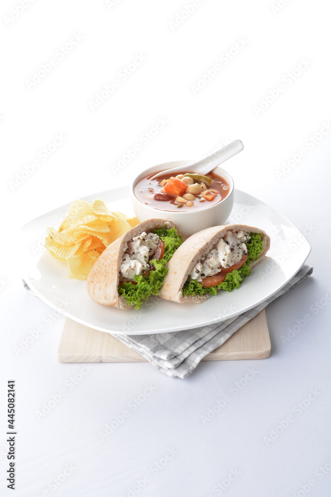 chicken salad kebab open pocket bread serve with tomato soup and crispy potato chips combo set  in white background asian vegan halal menu