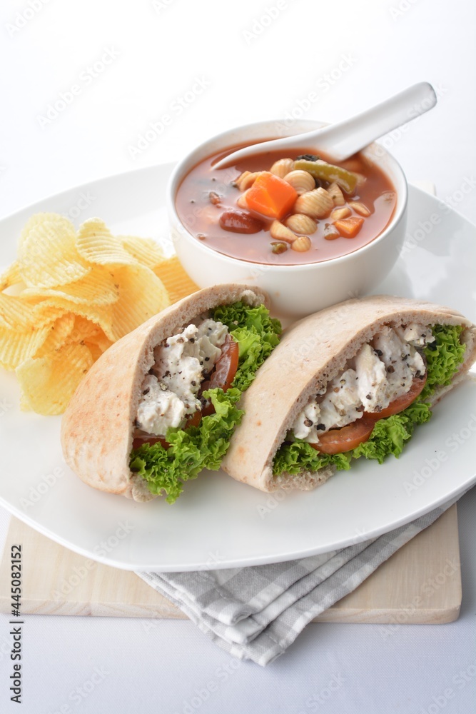 chicken salad kebab open pocket bread serve with tomato soup and crispy potato chips combo set in white background asian vegan halal menu chicken salad kebab open pocket bread serve with tomato soup and crispy potato chips combo set in white background asian vegan halal menu