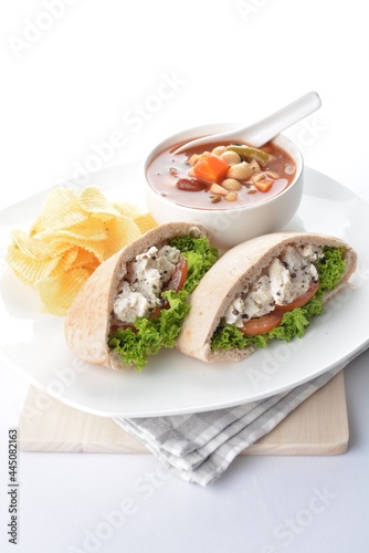 chicken salad kebab open pocket bread serve with tomato soup and crispy potato chips combo set in white background asian vegan halal menu