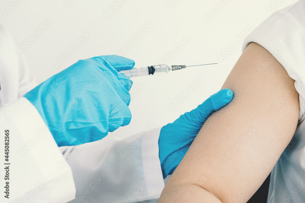 Female doctors vaccinated with syringes to prevent epidemics at hospitals, health care, and medical concepts Female doctors vaccinated with syringes to prevent epidemics at hospitals, health care, and medical concepts