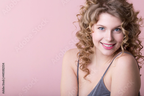 Portrait of body positive curly woman smiling looking at camera.