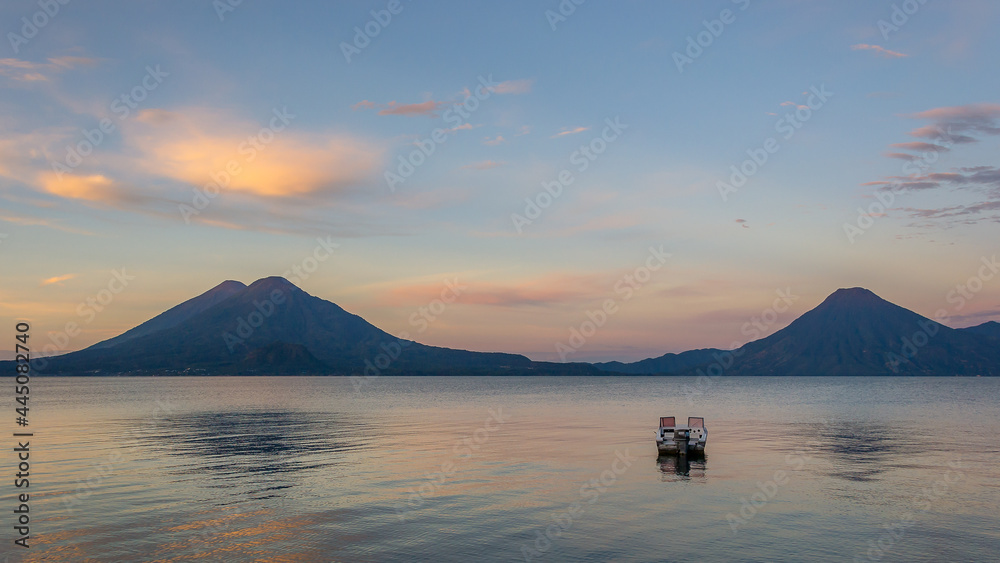 Spectacular landscape of a lonely boat at sunrise - Panajachel, Lake Atitlán, in the Guatemalan highlands, Central America Spectacular landscape of a lonely boat at sunrise - Panajachel, Lake Atitlán, in the Guatemalan highlands, Central America