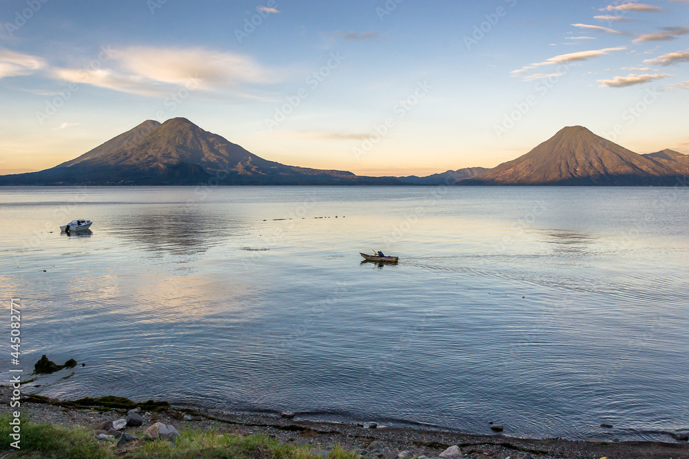 Spectacular landscape of a lonely fisherman in a boat at sunrise -  Panajachel, Lake Atitlán, in the Guatemalan highlands, Central America