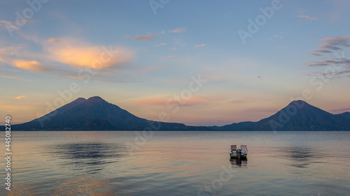 Spectacular landscape of a lonely boat at sunrise - Panajachel, Lake Atitlán, in the Guatemalan highlands, Central America photo