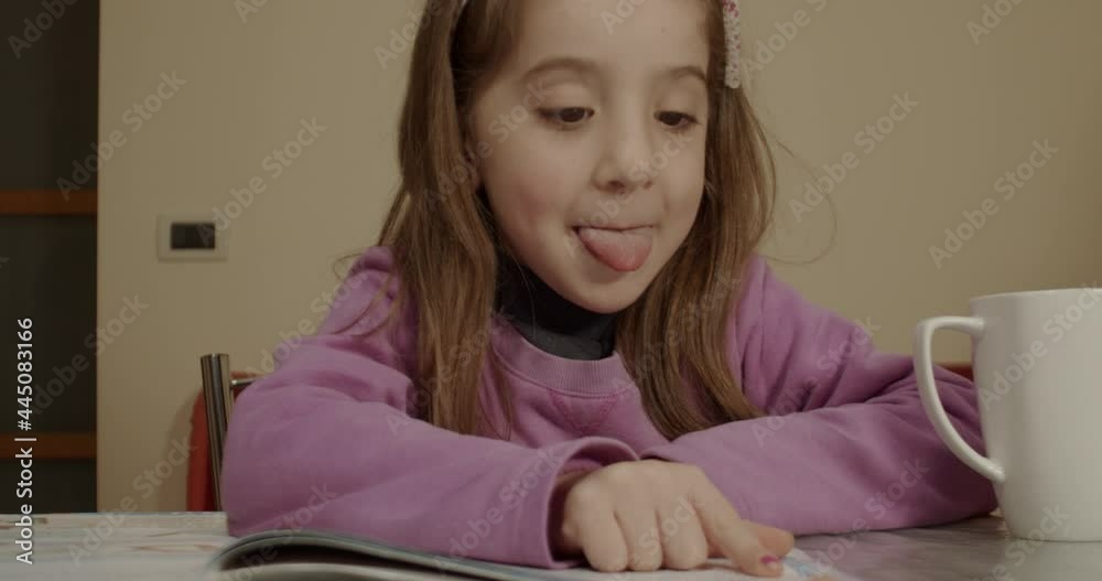 Little girl attending elementary school does her homework while learning to read Little girl attending elementary school does her homework while learning to read