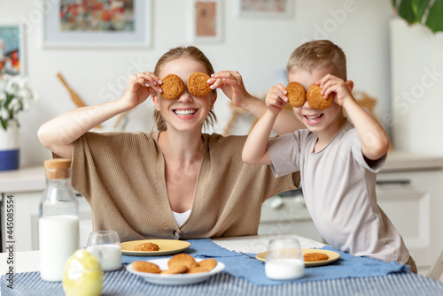 Mother and son playing with cookies during breakfast