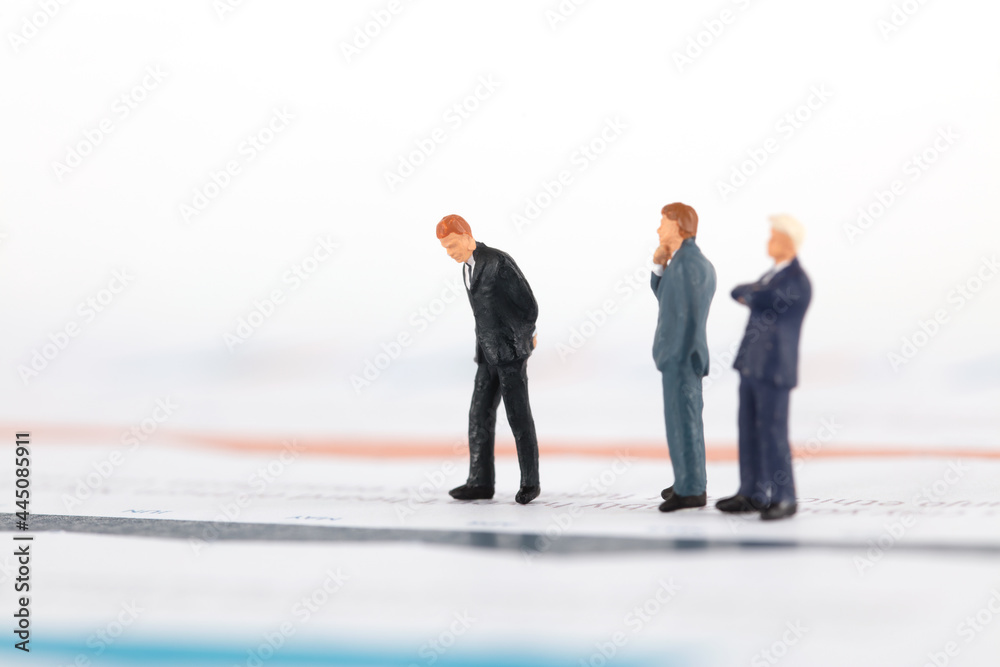 Businessman standing on financial charts thinking about problems Businessman standing on financial charts thinking about problems