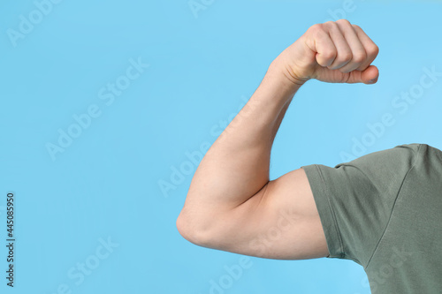 Arm of sporty male coach on color background