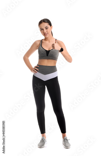 Sporty female coach showing thumb-up on white background